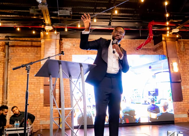 At the podium at a Gentlemen's Factory black-tie gala.